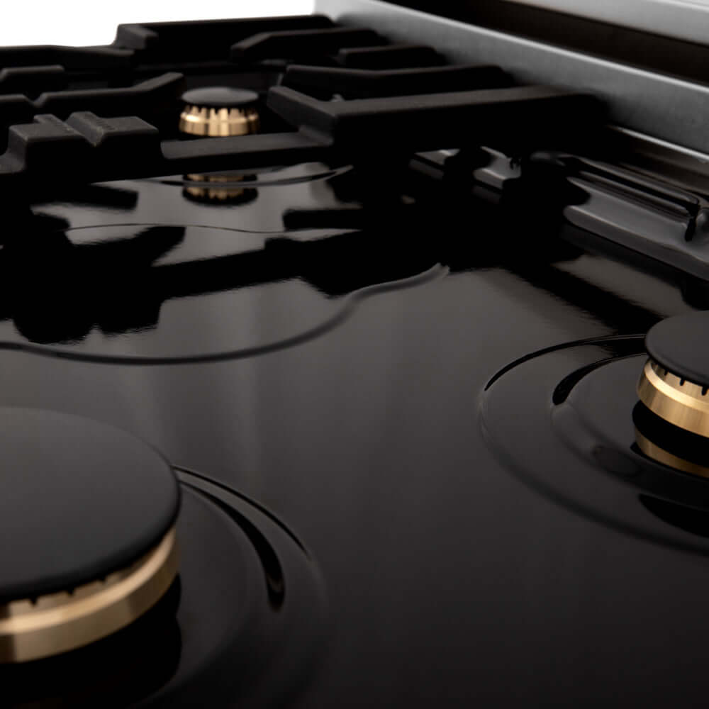 ZLINE Autograph Edition 30 in. 4.0 cu. ft. Dual Fuel Range with Gas Stove and Electric Oven in Stainless Steel with White Matte Door and Champagne Bronze Accents (RAZ-WM-30-CB) gas burners on black porcelain cooktop close-up.