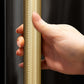 ZLINE Autograph Edition 72 in. 39.6 cu. ft. French Door Built-In Bottom Freezer Refrigerator with Water Dispensers and Ice Makers in Black Stainless Steel with Graphite Gray Interior and Champagne Bronze Helix Handles (GRBITZ-BS72-KCB) hand holding Helix handle showing knurled diamond texture.