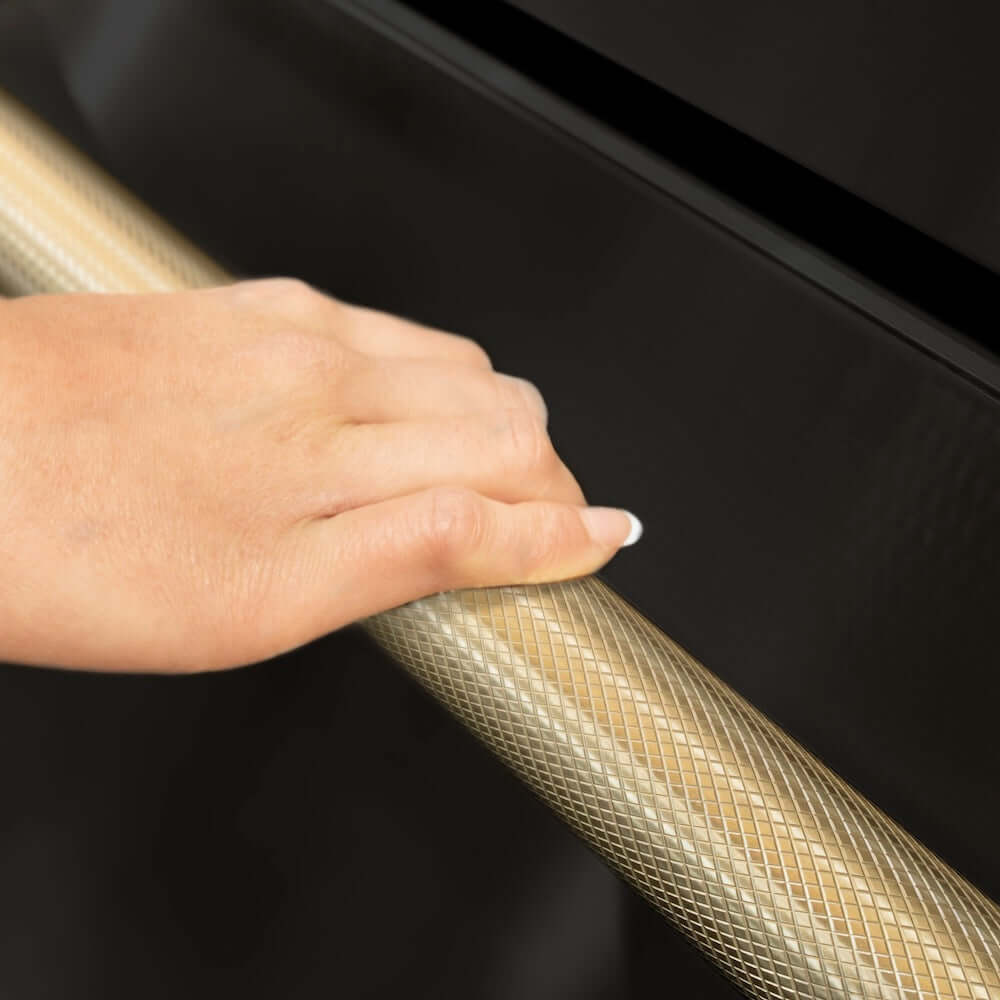 ZLINE Autograph Edition 36 in. 22.5 cu. ft. Counter-Depth French Door Refrigerator with Ice Maker in Fingerprint-Resistant Black Stainless Steel and Champagne Bronze Helix Handles (RFMZ-36-BS-KCB) hand holding Helix handle showing knurled diamond texture.