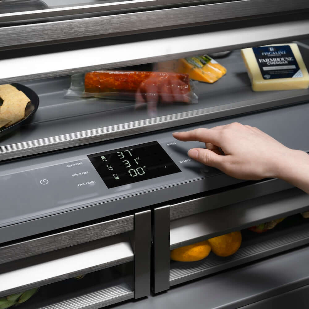 ZLINE Autograph Edition 36 in. 19.6 cu. ft. French Door Built-In Bottom Freezer Refrigerator with Water Dispenser and Ice Maker in Stainless Steel with Graphite Gray Interior and Champagne Bronze Helix Handles (GRBIVZ-30436KCB) hand adjusting digital temperature control inside refrigeration compartment with food items inside.