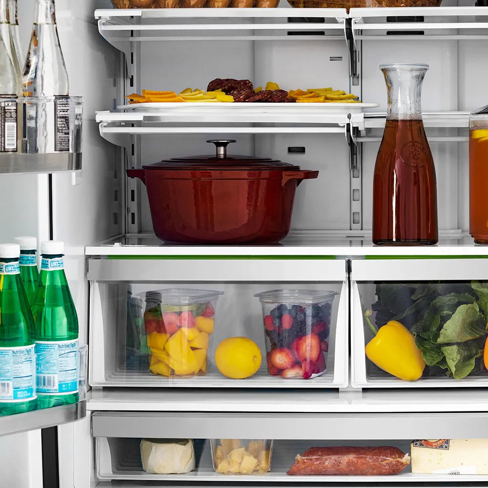 ZLINE Autograph Edition 36 in. 22.5 cu. ft. Counter-Depth French Door Refrigerator with Ice Maker in Fingerprint-Resistant Black Stainless Steel and Champagne Bronze Traditional Handles (RFMZ-36-BS-CB) food on shelves inside refrigeration compartment.