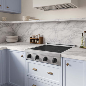 A ZLINE Autograph Edition 30 in. Paramount Induction Rangetop with 4 Element Cooktop in Satin Stainless Steel and Matte Black Accents (SINRTSZ-30-MB) installed in a kitchen with pale blue cabinets, a white marble backsplash, and a marble countertop.