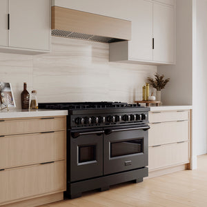 ZLINE 48 in. 6.7 cu. ft. Classic Gas Range with 8 Burner DuoPro™ Cooktop and Dual Ovens in Black Stainless Steel (PCGRB-48) in a custom kitchen with light wood cabinets, angled.