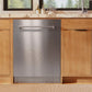 ZLINE 24 in. Monument Series 3rd Rack Dishwasher with Auto Door Open Drying, 44dBa, Stainless Steel Panel (DWMT-304-24) in a kitchen with wooden cabinets and a window view.
