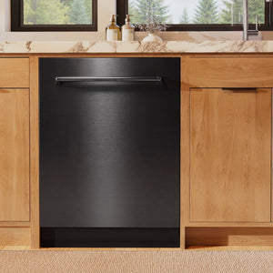 ZLINE 24 in. Monument Series 3rd Rack Dishwasher with Auto Door Open Drying, 44dBa, Black Stainless Steel Panel (DWMT-BS-24) in a kitchen with wooden cabinets and a window view of trees.