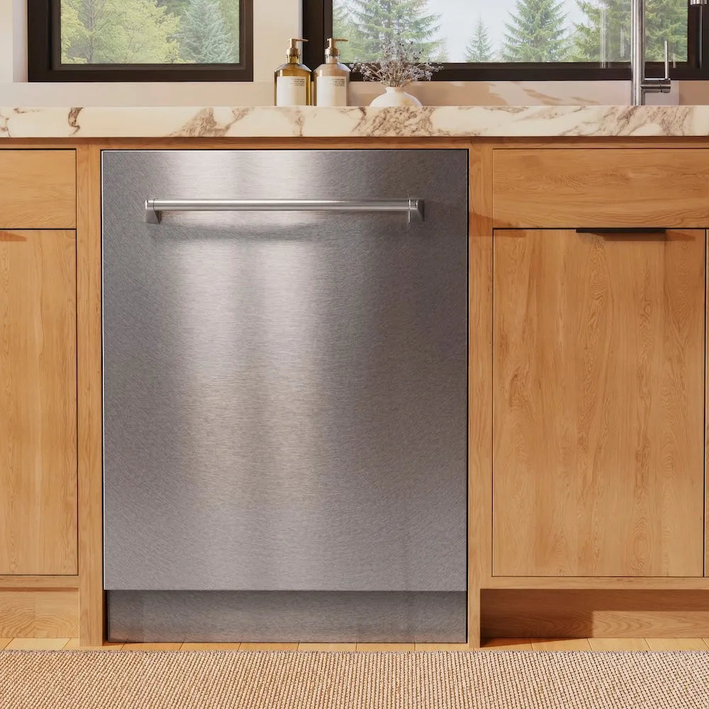 ZLINE 24 in. Monument Series 3rd Rack Dishwasher with Auto Door Open Drying, 44dBa, Satin Stainless Steel Panel (DWMT-SN-24) in a kitchen with wooden cabinets and a window view of trees.