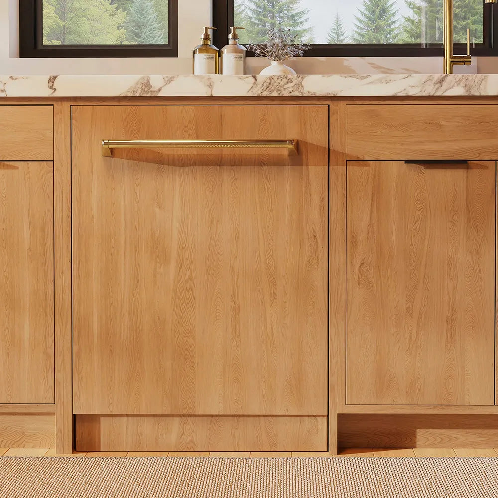 ZLINE Autograph Edition 24 in. Monument Series 3rd Rack Dishwasher with Auto Door Open Drying, 44dBa, Panel Ready with Polished Gold Handle (DWMTZ-24-G) in a kitchen with wooden cabinets and a window view.