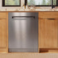 ZLINE Autograph Edition 24 in. Monument Series 3rd Rack Dishwasher with Auto Door Open Drying, 44dBa, Stainless Steel Panel with Matte Black Handle (DWMTZ-304-24-MB) in a kitchen with wooden cabinets and a window view.