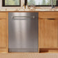 ZLINE Autograph Edition 24 in. Monument Series 3rd Rack Dishwasher with Auto Door Open Drying, 44dBa, Stainless Steel Panel with Polished Nickel Helix Handle (DWMTZ-30424-KPN) in a kitchen with wooden cabinets and a window view.