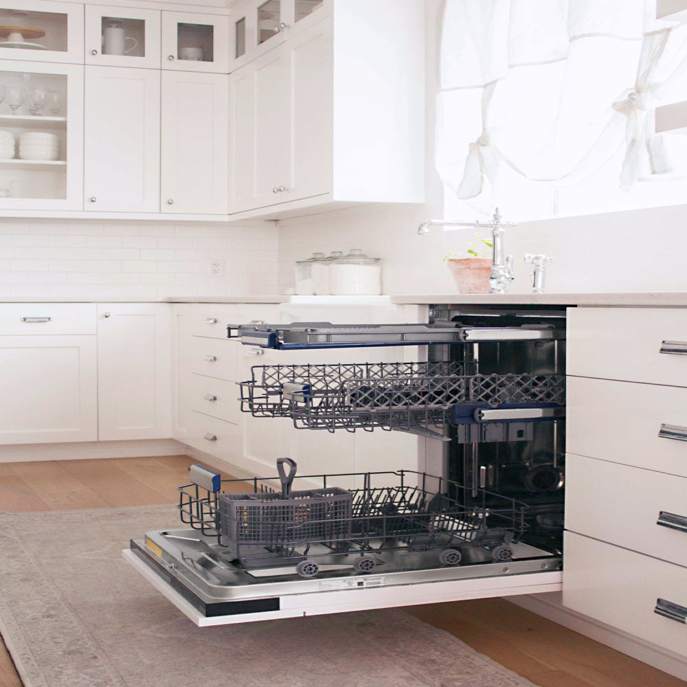 ZLINE Autograph Edition 24 in. Tallac Series 3rd Rack Dishwasher with Auto Door Open Drying, 51dBa, Panel Ready with Matte Black Handle (DWVZ-24-MB) side, open, with racks extended, shown in a bright kitchen setting.
