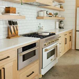 ZLINE Autograph Edition 30 in. 1.2 cu. ft. Built-In Microwave Drawer in Stainless Steel with Polished Gold Accents (MWDZ-30-G) in a kitchen with stainless steel appliances, wooden cabinets, and white tiled walls.