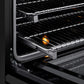 ZLINE 30 in. 4.2 cu. ft. Paramount Induction Range with 4 Element Cooktop and Electric Convection Oven in Black Stainless Steel (SINRB-30) close-up, open oven with racks extended, showing interior components.