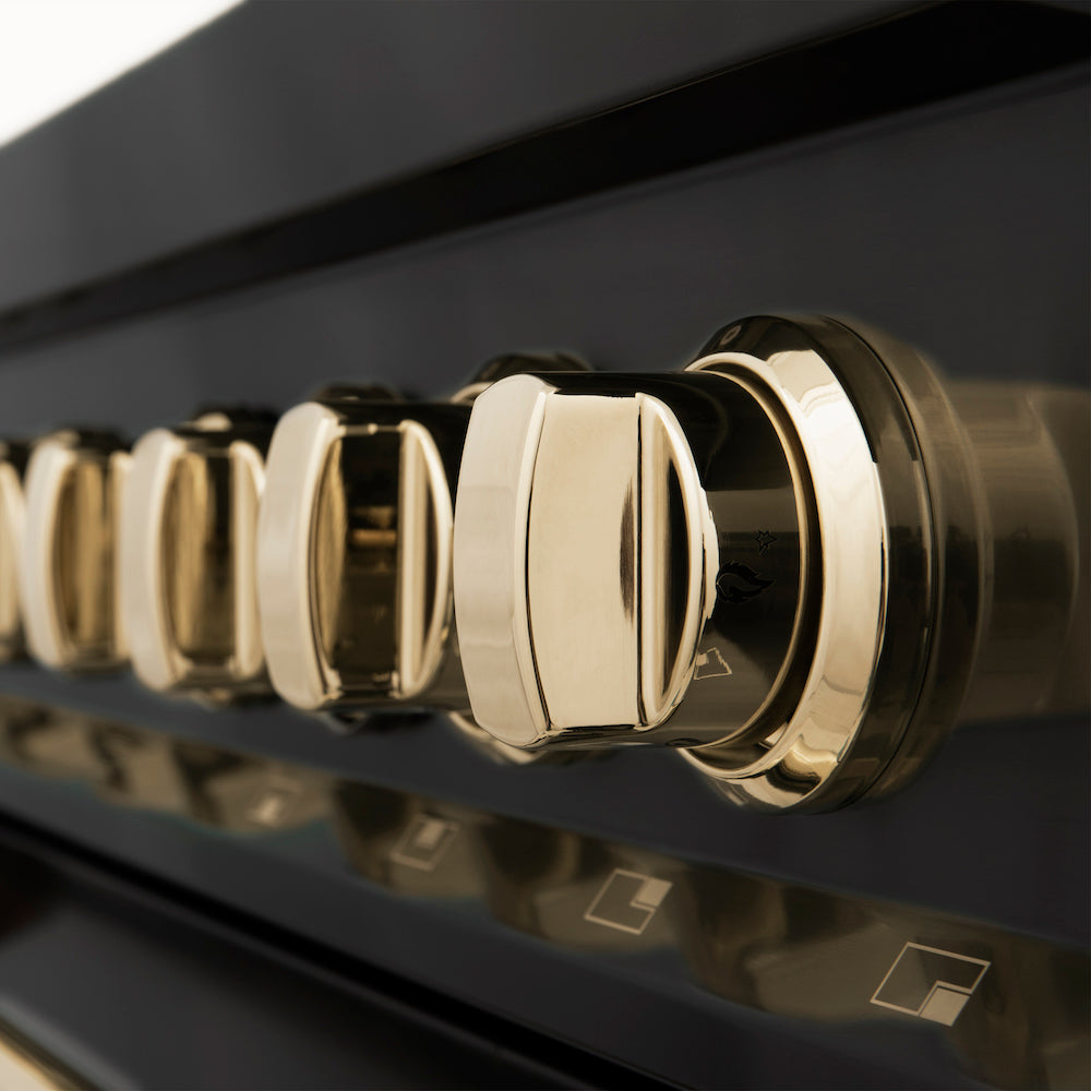 ZLINE Autograph Edition Polished Gold knobs on a black stainless steel appliance close up.