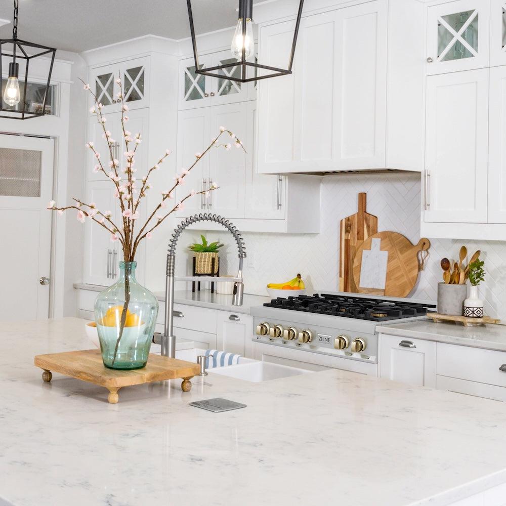 ZLINE Autograph Edition 30 in. Legacy Gas Rangetop with 4 Burners and Porcelain Cooktop in Stainless Steel with Polished Gold Accents (RTZ-30-G) in a luxury cottage-style kitchen from side.