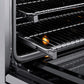 ZLINE Autograph Edition 36 in. 5.2 cu. ft. Paramount Induction Range with 5 Element Cooktop and Electric Convection Oven in Satin Stainless Steel with Matte Black Accents (SINRSZ-36-MB) close-up, open oven with racks extended, showing interior components.