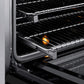 ZLINE 36 in. 5.2 cu. ft. Paramount Induction Range with 5 Element Cooktop and Electric Convection Oven in Stainless Steel with Black Matte Door (SINR-BLM-36) close-up, open oven with racks extended, showing interior components.