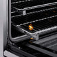 ZLINE Autograph Edition 30 in. 4.2 cu. ft. Paramount Induction Range with 4 Element Cooktop and Electric Convection Oven in Stainless Steel with Champagne Bronze Accents (SINRZ-30-CB) close-up, open oven with racks extended, showing interior components.