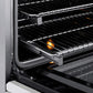 ZLINE Autograph Edition 30 in. 4.2 cu. ft. Paramount Induction Range with 4 Element Cooktop and Electric Convection Oven in Stainless Steel with White Matte Door and Matte Black Accents (SINRZ-WM-30-MB) close-up, open oven with racks extended, showing interior components.