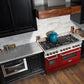 ZLINE 48 in. 6.0 cu. ft. Legacy Dual Fuel Range with 7 Burner Gas Cooktop and 2 Electric Ovens in Stainless Steel and Red Gloss Doors (RA-RG-48) in a luxury kitchen.