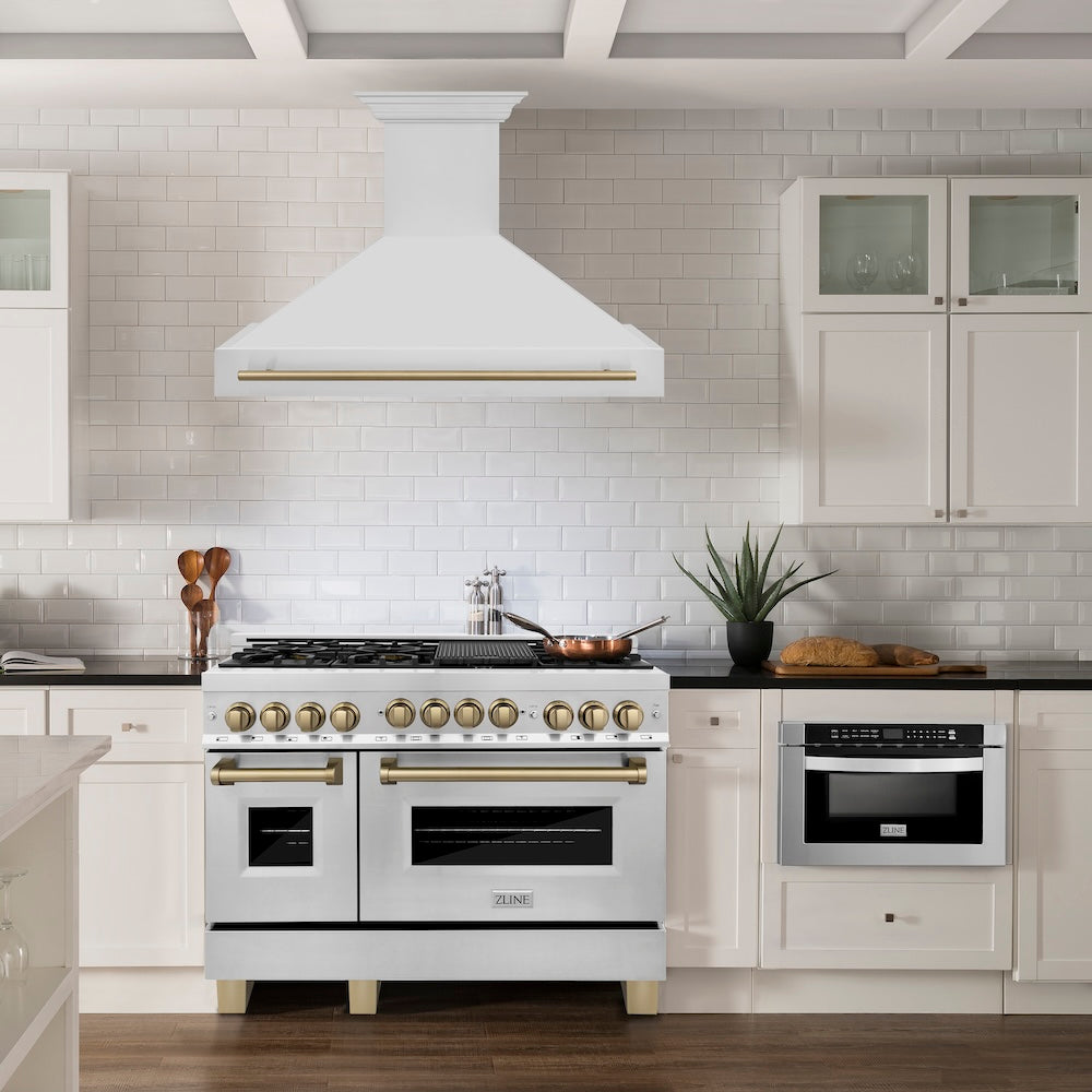 ZLINE Autograph Edition 48 in. Stainless Steel Range Hood with Stainless Steel Shell and Champagne Bronze Handle (8654STZ-48-CB) in a farmhouse-style kitchen above matching range.