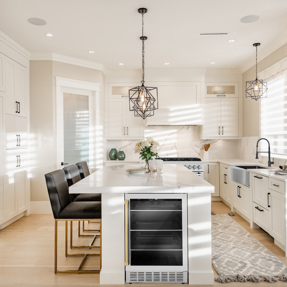ZLINE Autograph Edition 24 in. Monument 154 Can Beverage Fridge in Stainless Steel with Polished Gold Accents (RBVZ-US-24-G) in a kitchen with white cabinets, marble countertops, and stainless steel appliances.