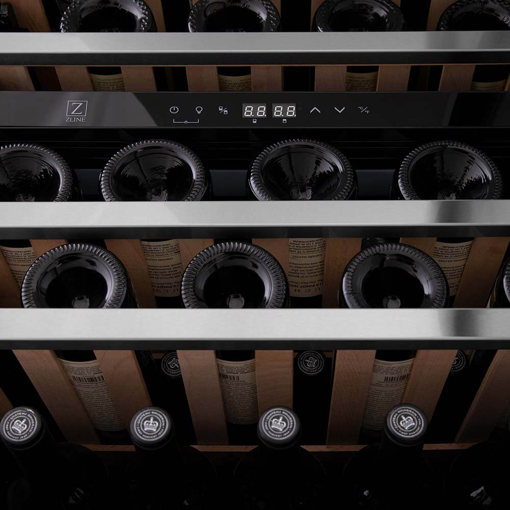 ZLINE Autograph Edition 24 in. Monument Dual Zone 44-Bottle Wine Cooler in Stainless Steel with Champagne Bronze Accents (RWVZ-UD-24-CB) close-up, wine bottles one wooden shelves from below.