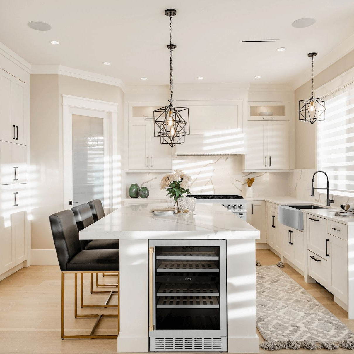 ZLINE Autograph Edition 24 in. Monument Dual Zone 44-Bottle Wine Cooler in Stainless Steel with Champagne Bronze Accents (RWVZ-UD-24-CB) built-in to an island in a cottage-style kitchen.