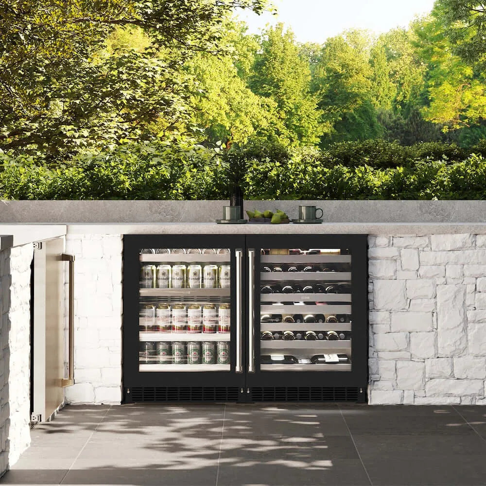 ZLINE 24 in. Touchstone 151 Can Beverage Fridge With Black Matte Glass Door (RBSO-BLM-24) front, in an outdoor patio area with a matching wine cooler against a stone wall and greenery.