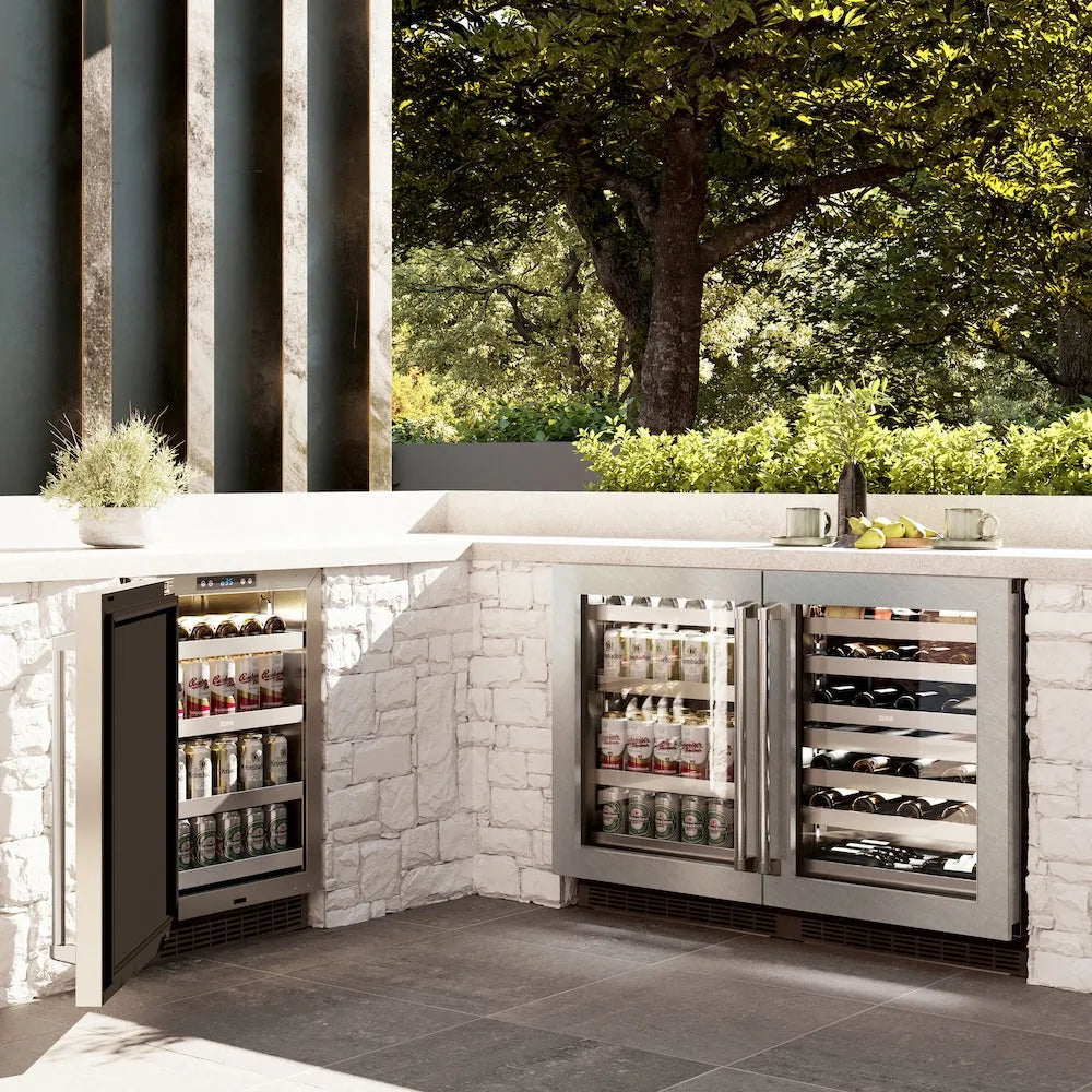 ZLINE 24 in. Touchstone Dual Zone 44 Bottle Wine Cooler with Satin Stainless Steel Glass Door (RWDO-SN-24) side, in an outdoor patio area against a stone wall and greenery.