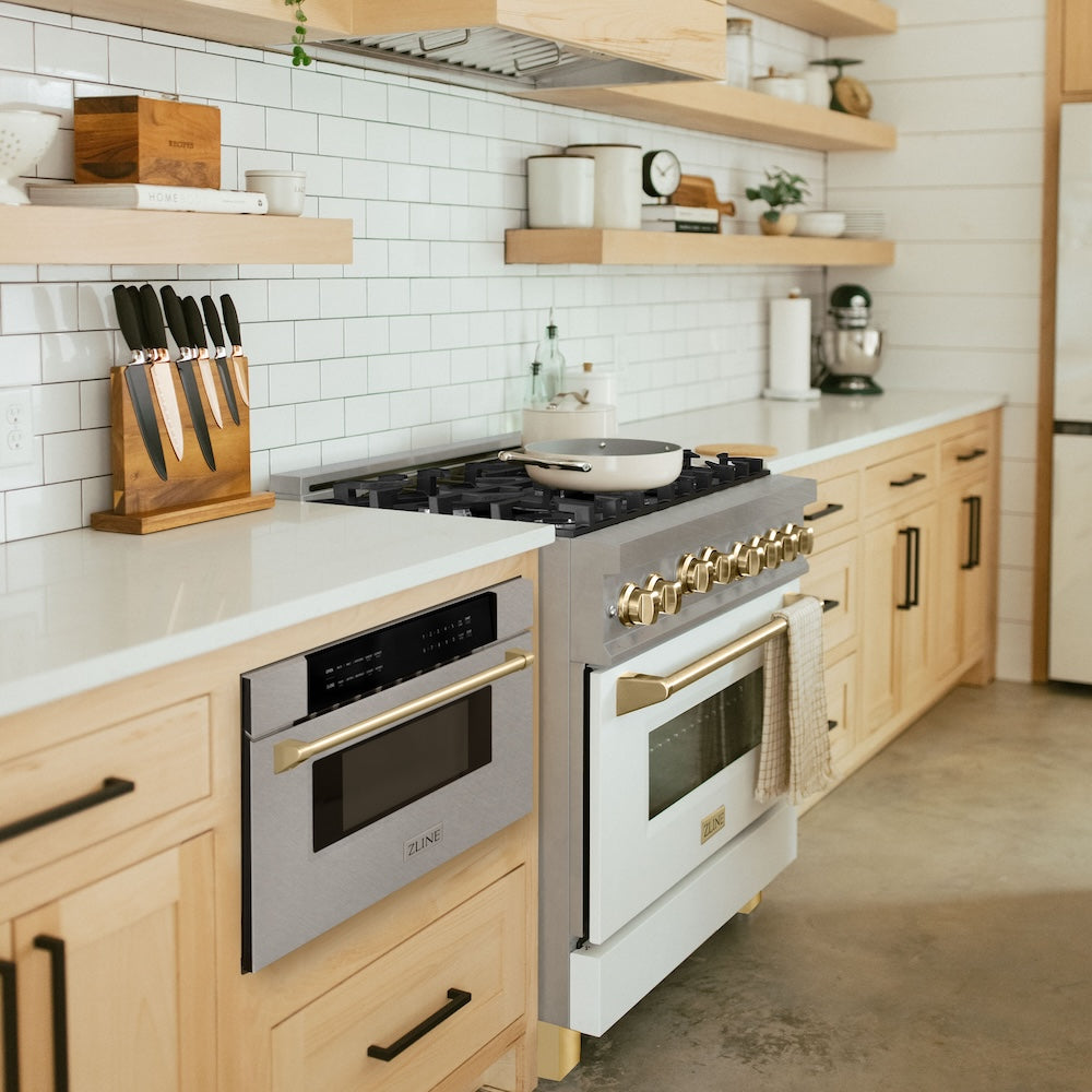 ZLINE Autograph Edition 30 in. 1.2 cu. ft. Built-In Microwave Drawer in Satin Stainless Steel with Polished Gold Accents (MWDZ-30-SS-G) in a kitchen with matching stainless steel appliances, wooden cabinets, and white tiled walls.