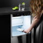 ZLINE Autograph Edition 15 in. Touchstone Gourmet Ice Maker with Drain Pump and White Matte Door with Matte Black Handle (IGMDZ-WM-15-MB) lifestyle, a woman scooping ice from inside the ice maker.