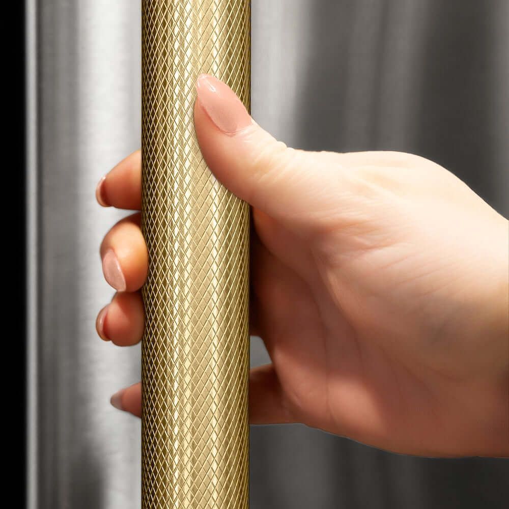 ZLINE Autograph Edition 36 in. 19.8 cu. ft. Built-In Bottom Freezer Refrigerator with Water Dispenser and Ice Maker in Stainless Steel with Graphite Gray Interior and Polished Gold Helix Handles (GRBITZ-30436KG) hand holding Helix handle showing knurled diamond texture.