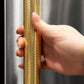 ZLINE Autograph Edition 15 in. Touchstone Clear Cube Ice Maker with Drain Pump and Solid Stainless Steel Door with Polished Gold Helix Handle (ICCDZ-ST-15-KG) hand holding Helix handle showing knurled diamond texture.