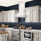 ZLINE Wooden Wall Mount Range Hood in Cottage White - Includes Motor (KPTT) side, in a luxury cottage-style kitchen with matching appliances.