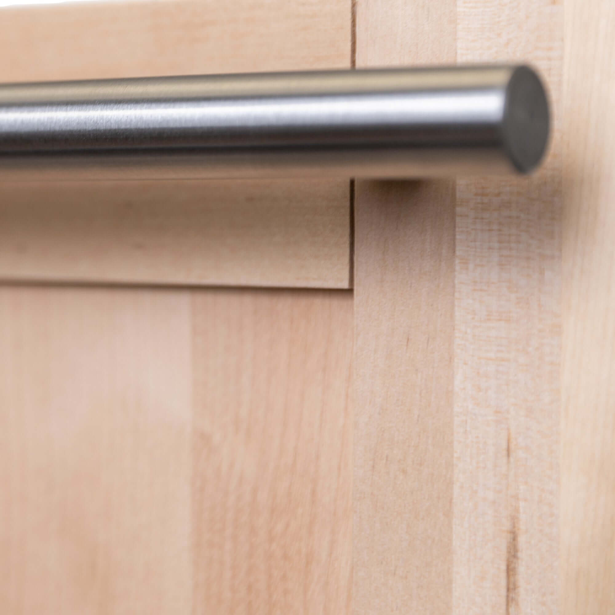 Modern handle and unfinished wood panel close up right.