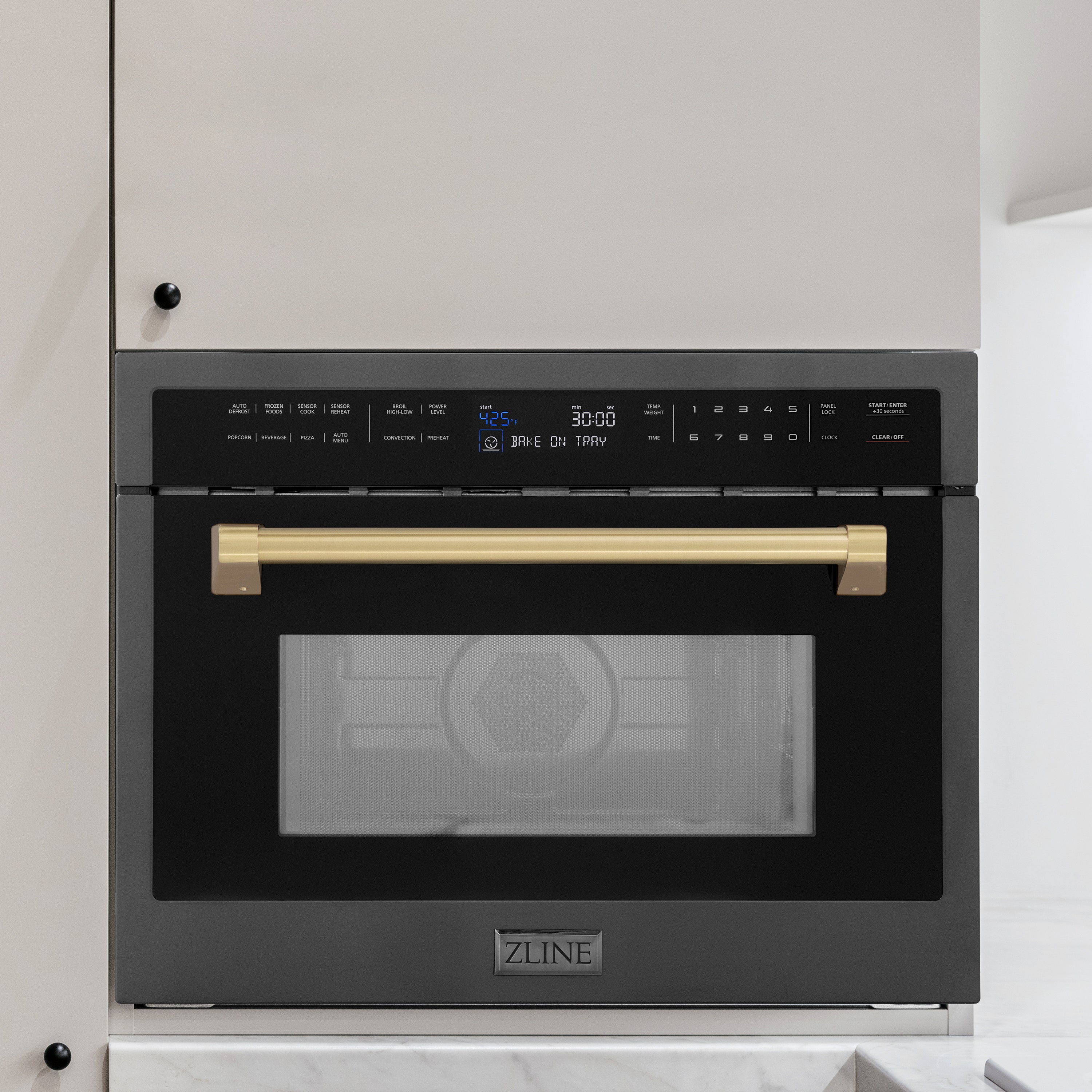 ZLINE Autograph Edition 24 in. 1.6 cu ft. Built-in Convection Microwave Oven in Black Stainless Steel with Champagne Bronze Accents (MWOZ-24-BS-CB) built-in to beige kitchen cabinetry.