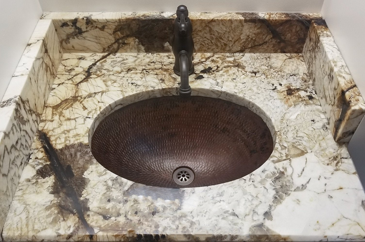 Premier Copper Sink Drain in Oil Rubbed Bronze in copper sink with marble counter