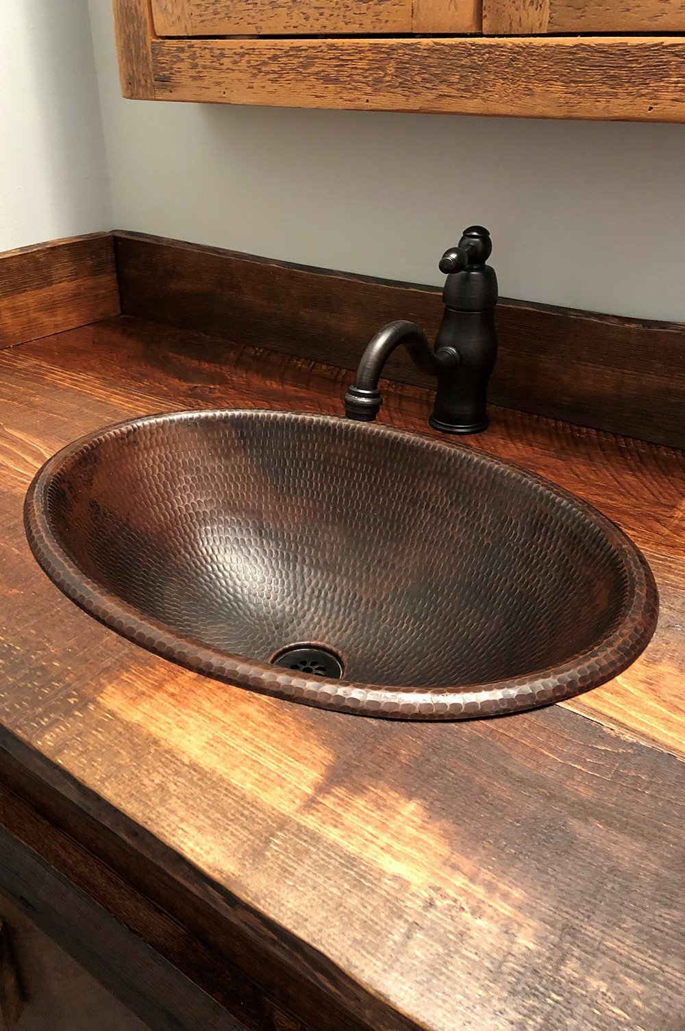 Premier Copper Sink Drain in Oil Rubbed Bronze in copper sink with rustic wood counter