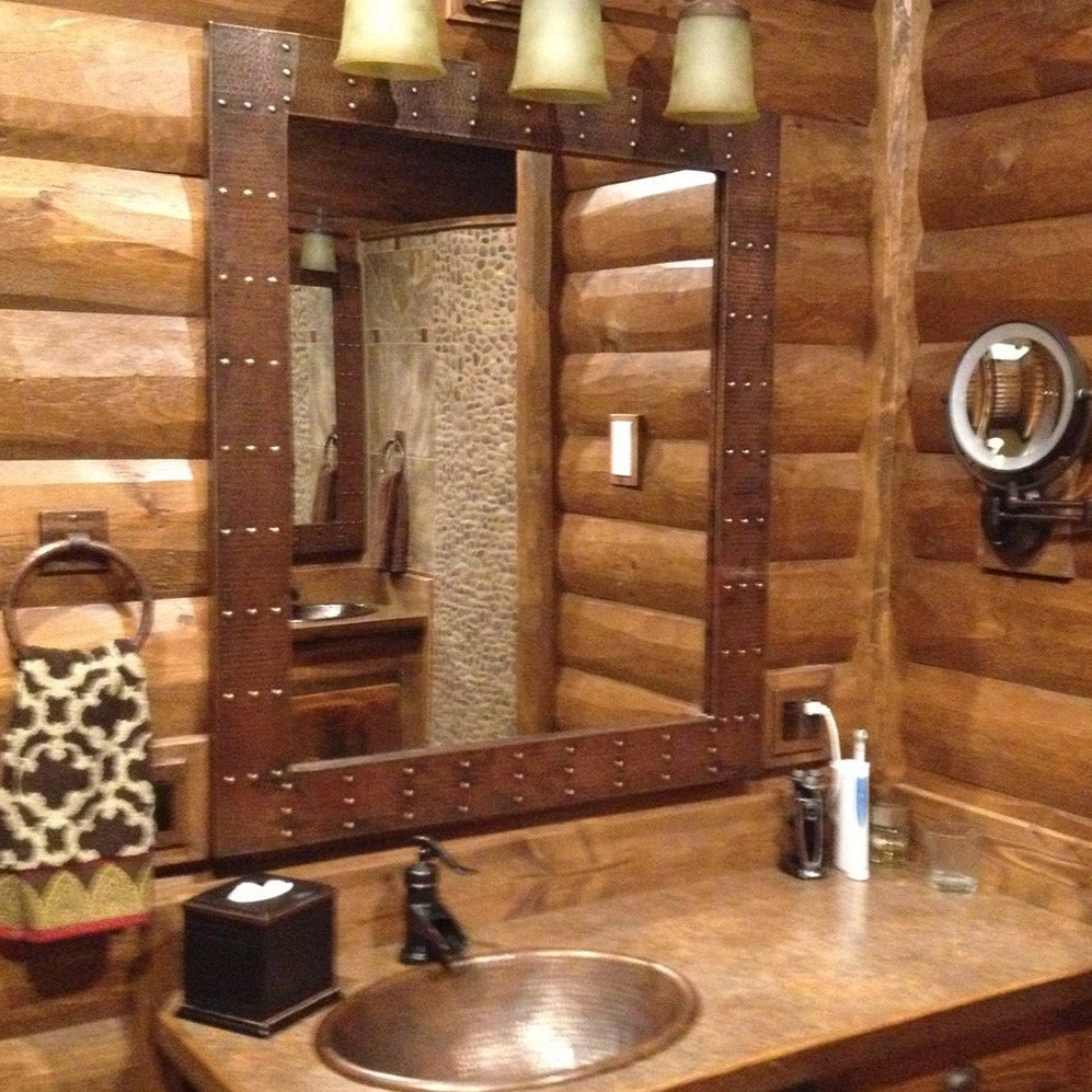 36" Rectangle Hammered Copper Mirror with rivet embellishments in a wooden cabin bathroom