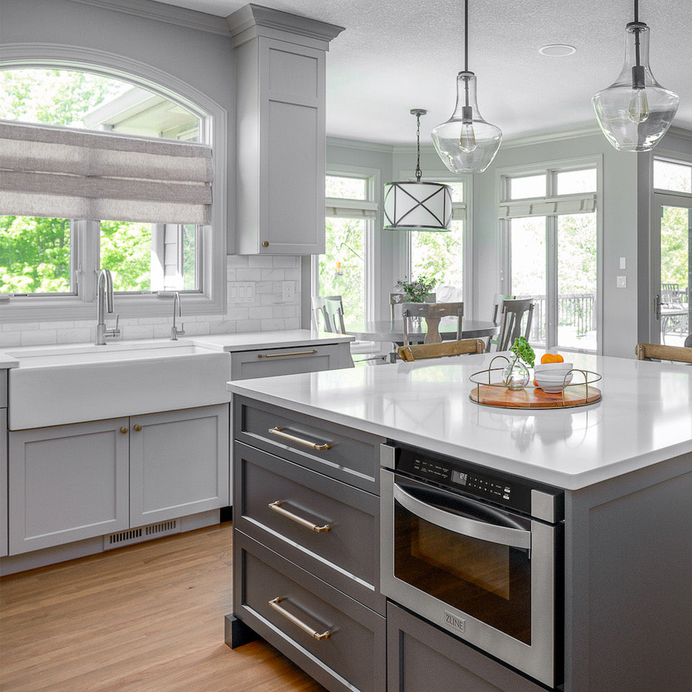ZLINE Built-in Microwave Drawer, sink, beverage faucet, and faucet in a farmhouse-style kitchen with grey cabinets and marble countertops.