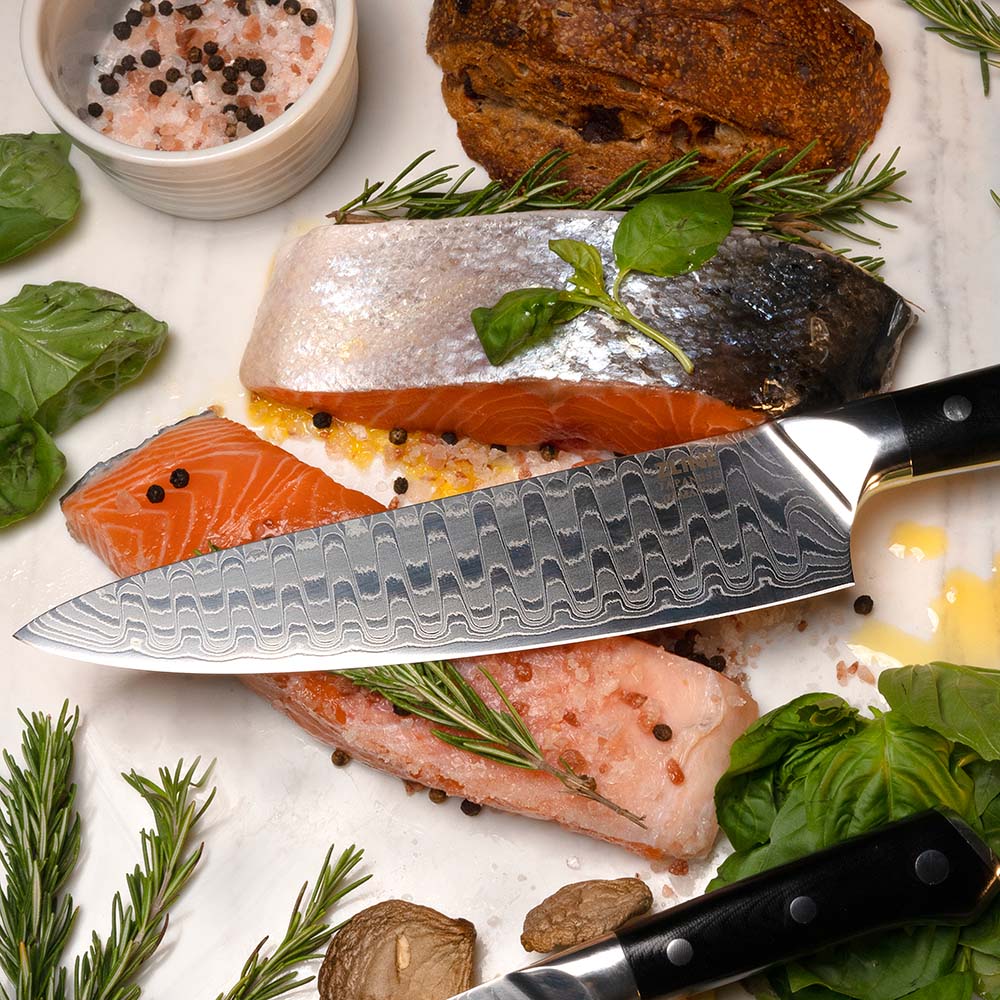 ZLINE Japanese Damascus steel chef knife on freshly cut fish with garnish.