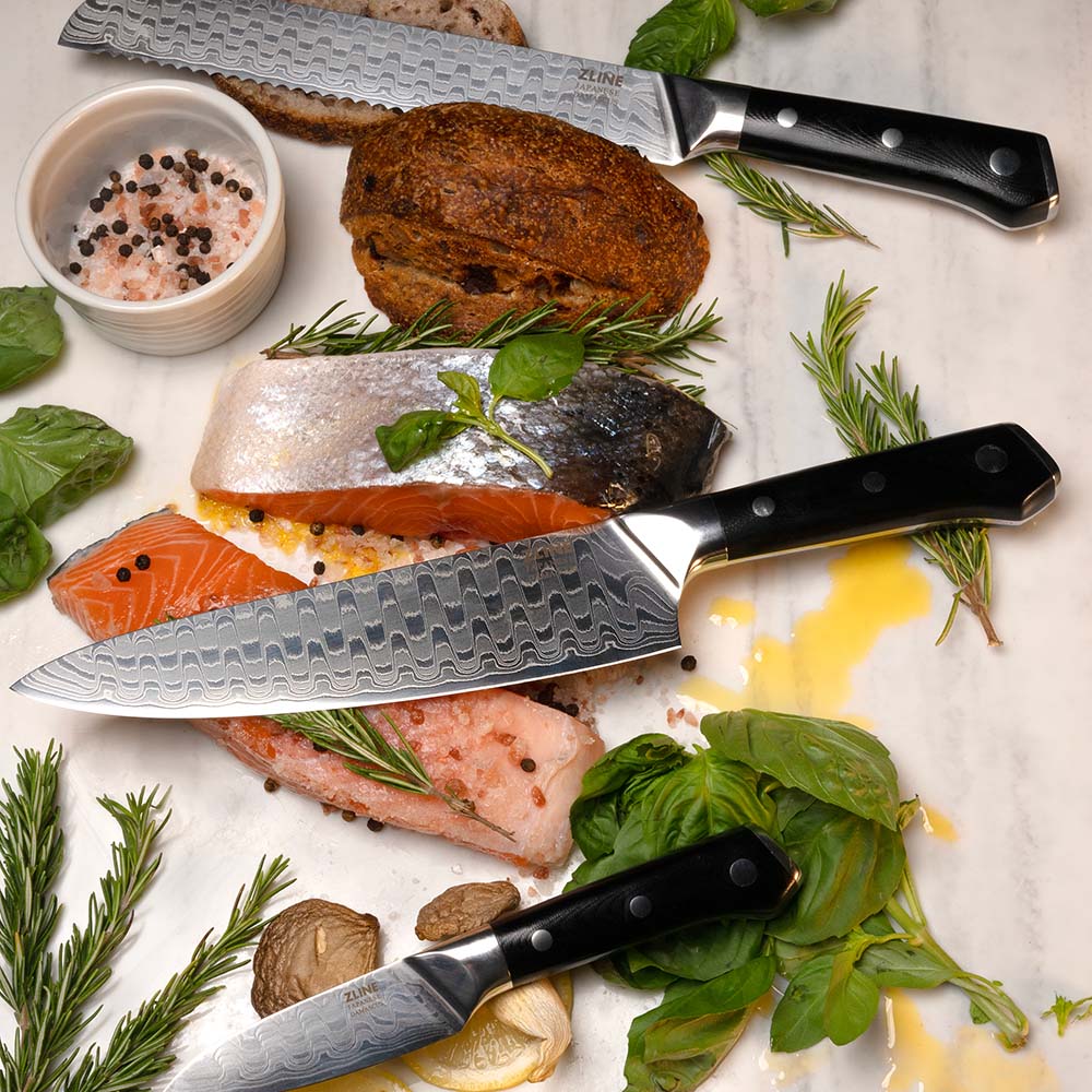 ZLINE Japanese Damascus steel knife set on countertop with fish and garnishes.