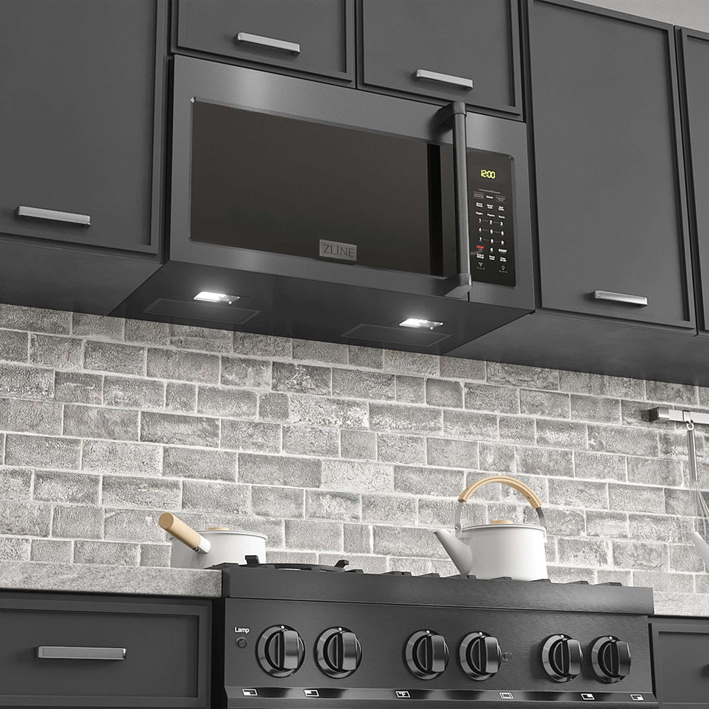 ZLINE Black Stainless Steel Over the Range Microwave in a modern kitchen above cooktop with lighting on.