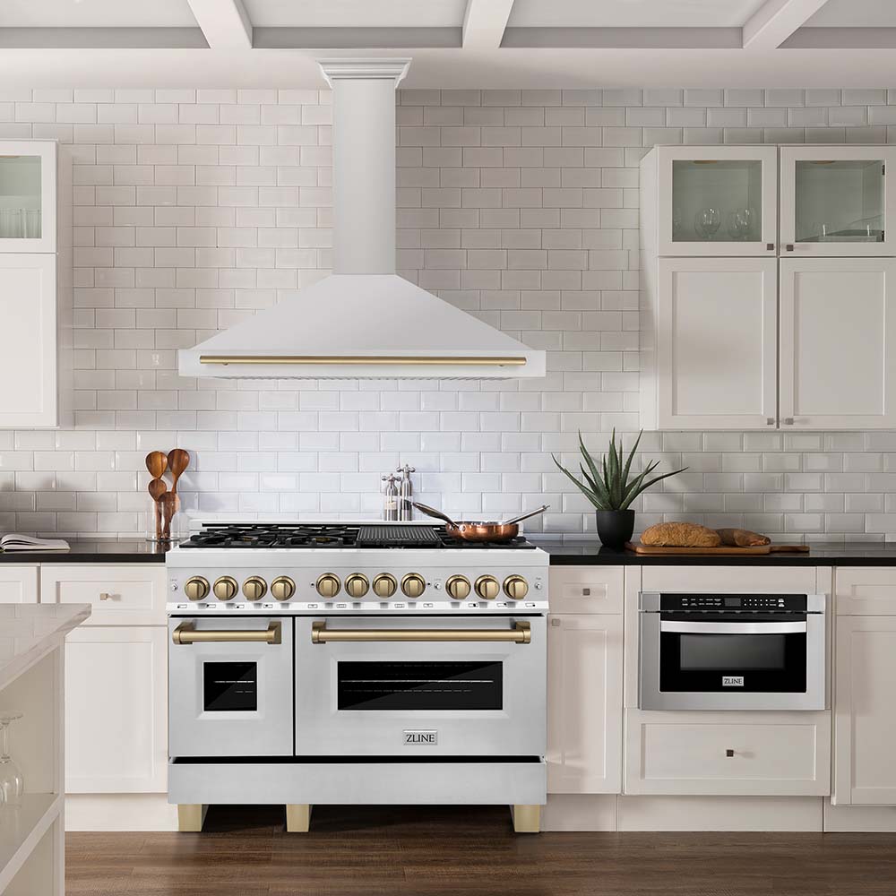 Stainless steel range and range hood with champagne bronze accents in a farmhouse kitchen