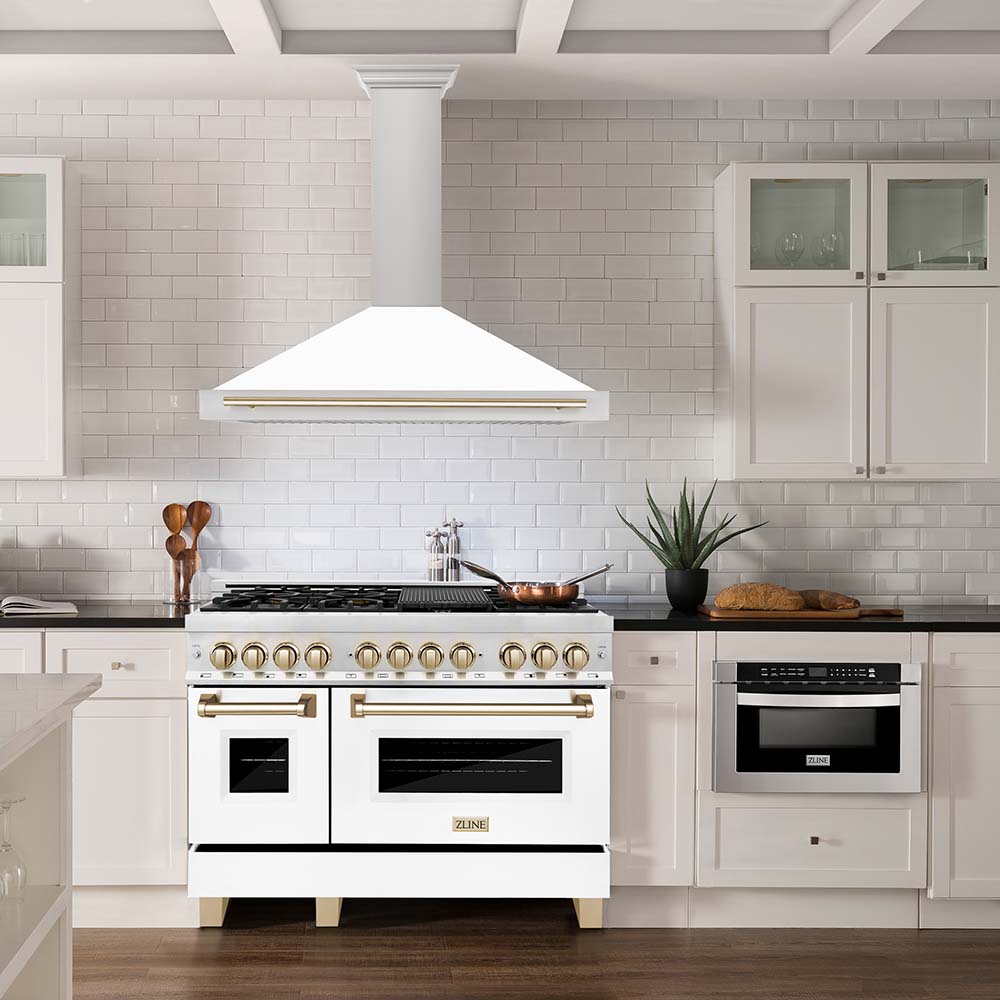 White matte and polished gold range and range hood in farmhouse kitchen
