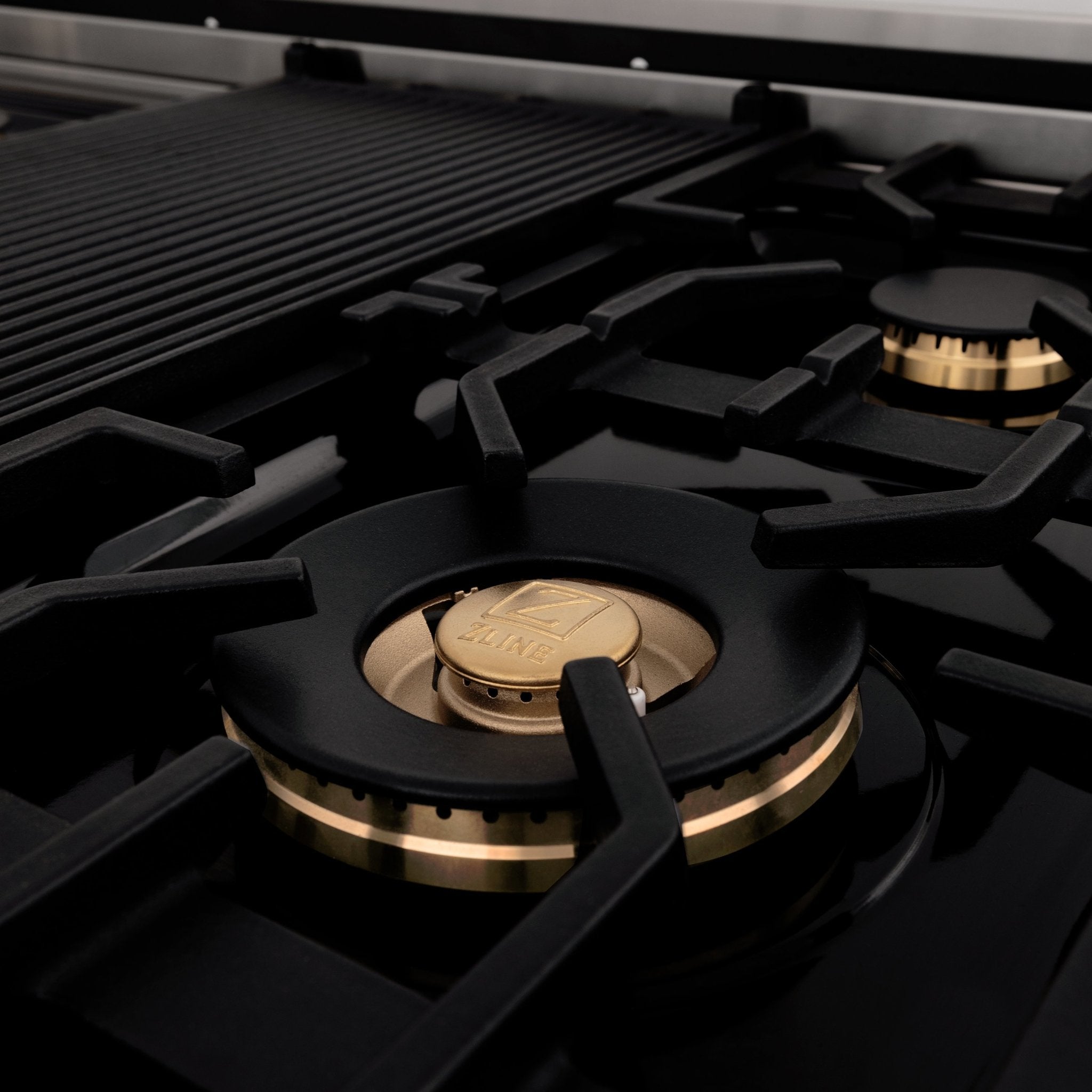 ZLINE Brass Burners on black porcelain cooktop with cast-iron grates.