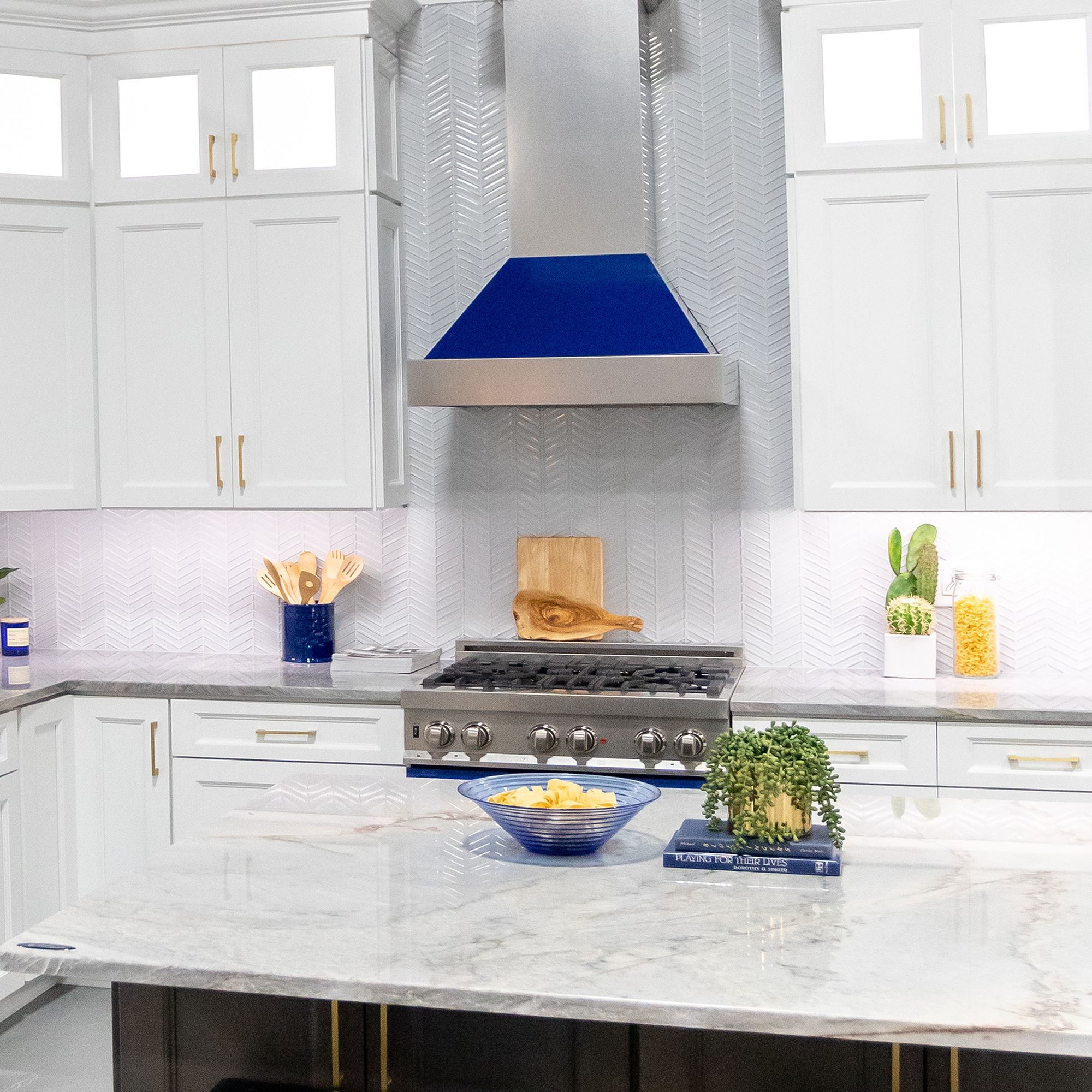 ZLINE Ducted Fingerprint Resistant Stainless Steel Range Hood with Blue Gloss Shell (8654BG) with matching blue gloss range in a white cottage-style kitchen from front.