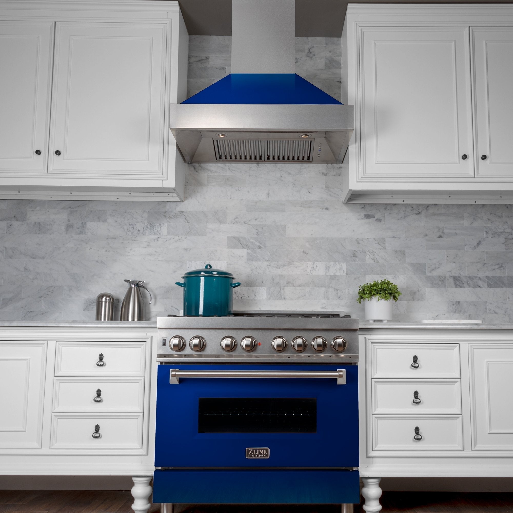 ZLINE Ducted Fingerprint Resistant Stainless Steel Range Hood with Blue Gloss Shell (8654BG) with short chimney in a kitchen with matching blue gloss range from front under.