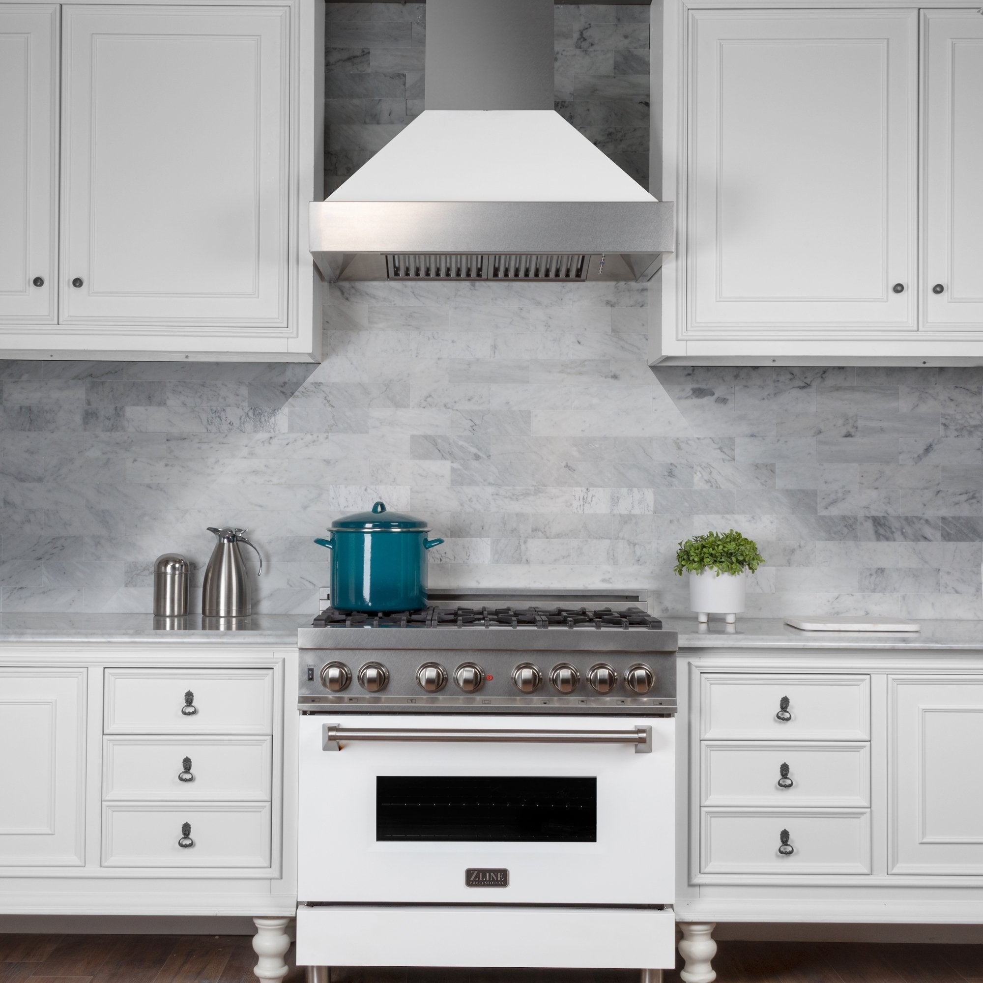 ZLINE Fingerprint Resistant Stainless Steel Range Hood With White Matte Shell (8654WM) with a short chimney above a matching kitchen range from front.