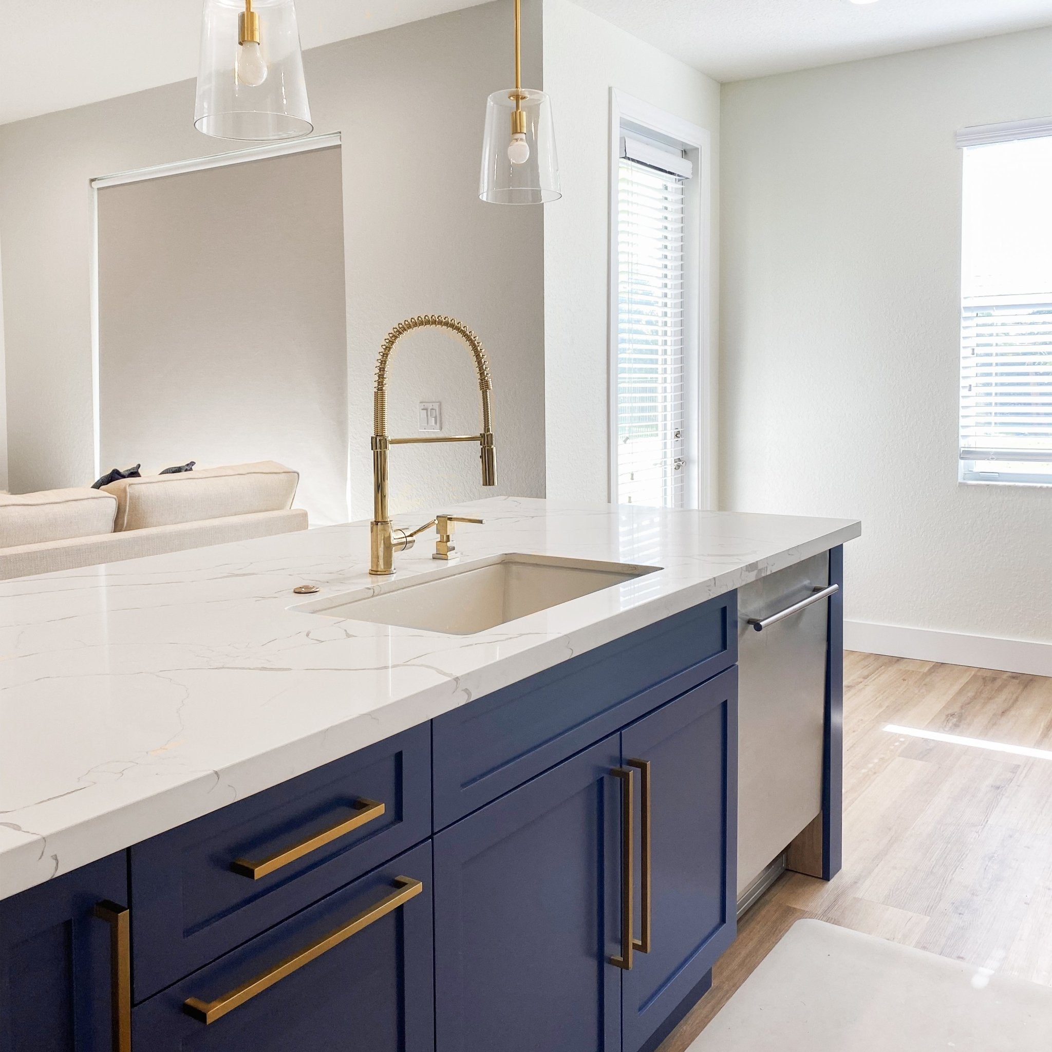ZLINE Sierra Kitchen Faucet (SRA-KF) with Polished Gold Finish in luxury kitchen with white counters and blue cabinets